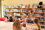 Bibliothek der Kita Kinderland, Lesetisch im Vordergrund, im Hintergrund Bücherregal mit Kinderbücher 