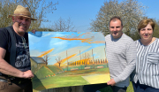Herr Scheunemann mit 2 weiteren Mühlhofern die ein gezeichnetes Bild des zukünftigen Dorfplatzes hochalten